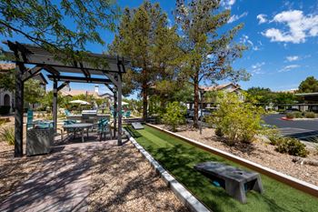 A patio with a table and chairs under a pergola.